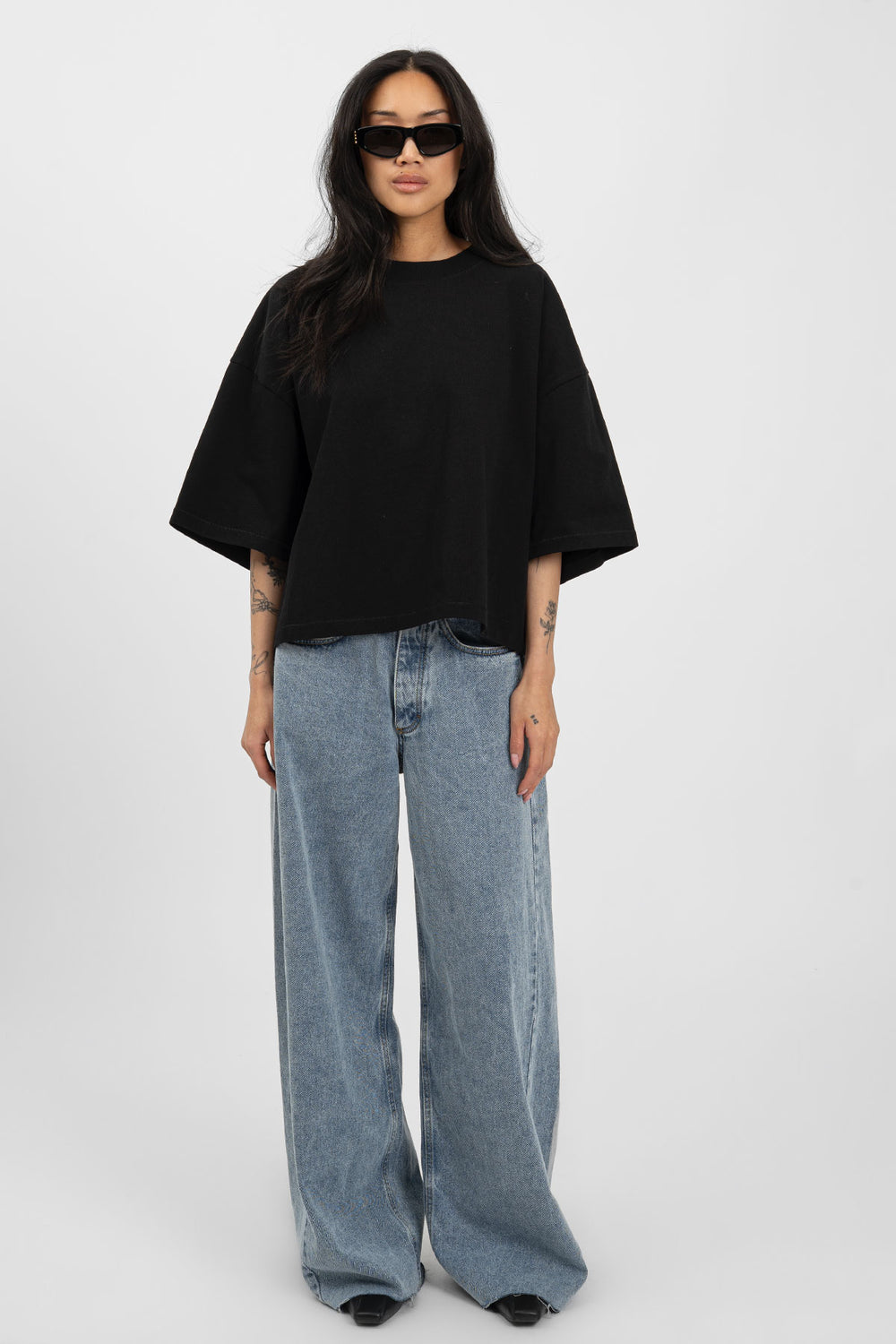 Black boxy T-shirt with a wide body, straight side line, and shorter hem